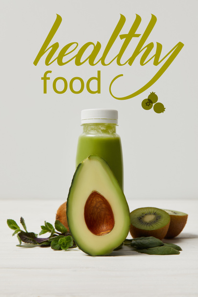 зелена детоксикаційна смузі з авокадо, ківі та м'ятою на білій дерев'яній поверхні, напис здорової їжі
 - Фото, зображення