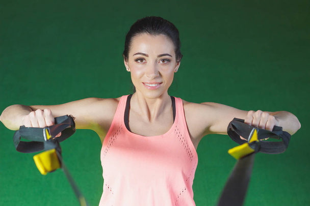 Sportieve jonge vrouw maakt sport oefeningen in de sportschool, Softfocus achtergrond - Foto, afbeelding