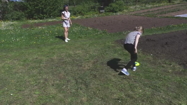 Little girl and woman playing with flying disc - Záběry, video