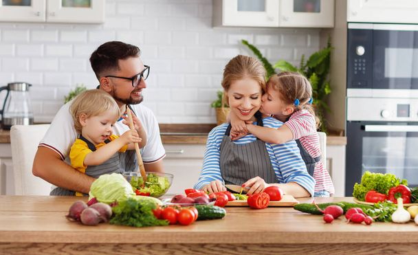 familia feliz con el niño preparando ensalada de verduras en hom
 - Foto, Imagen