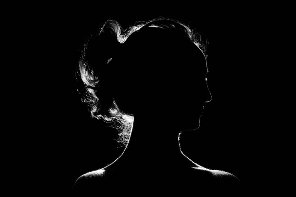 Silhouette of a beautiful girl on a black background - Фото, зображення