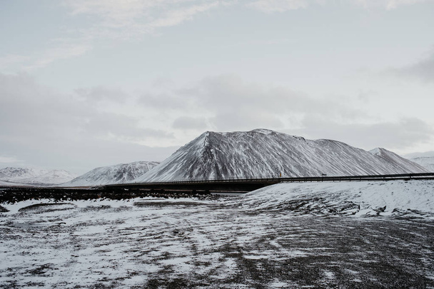 eine Brücke durch eine schneebedeckte Landschaft in snaefellsnes, Island. - Foto, Bild