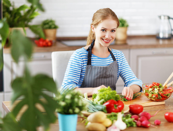 boldog asszony készül a konyhában, és növényi saláta - Fotó, kép