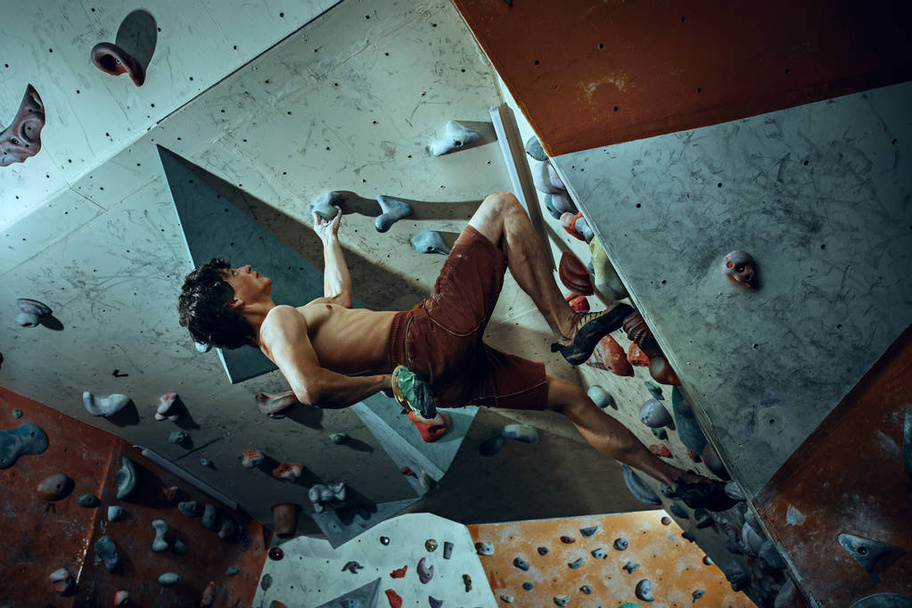 Free climber young man climbing artificial boulder indoors - Fotografie, Obrázek
