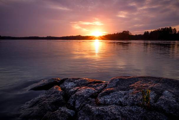 a tó egy kis növénytermesztés a sziklák a naplemente - Fotó, kép