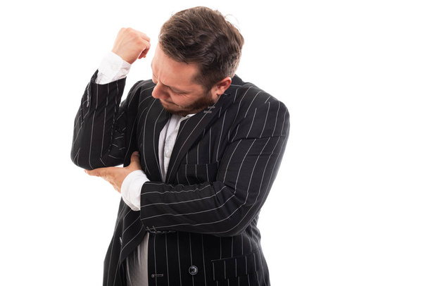 Retrato de homem de negócios mostrando gesto de dor no cotovelo isolado em fundo branco com área de publicidade copyspace
 - Foto, Imagem