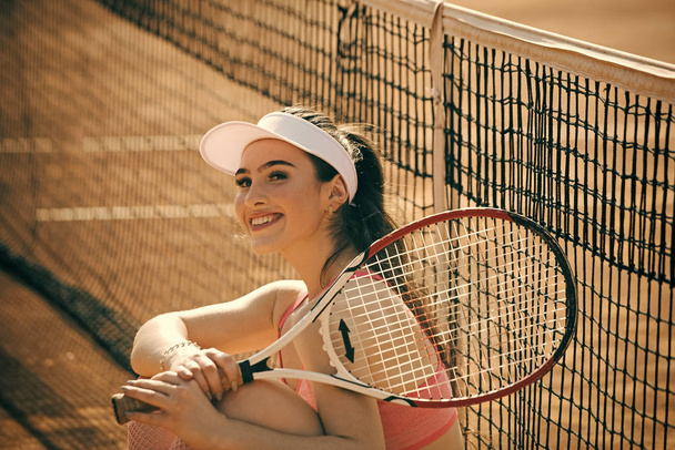 Advertising of tennis rackets. Happy smiling woman tennis player at court - Fotó, kép