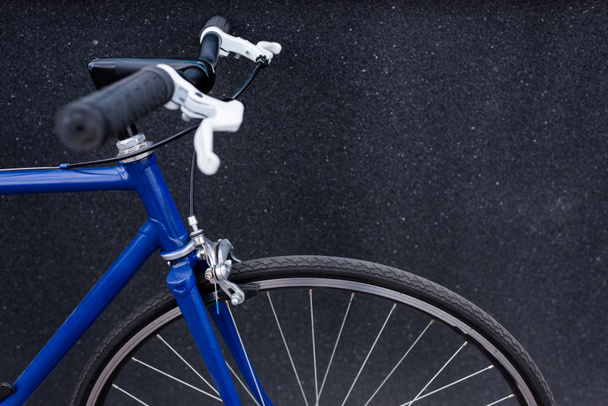 one blue bicycle near grey wall on street - Photo, Image
