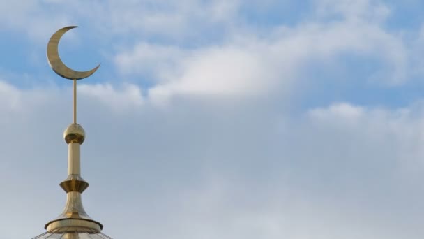 De gouden halve maan van de islamitische minaret in de linkerhoek van het frame tegen de achtergrond van snel bewegende wolken. Close-up. Timelapse. - Video