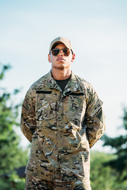 portrait of african american soldier in military uniform, cap and sunglasses - Fotó, kép