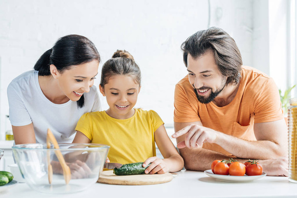happy young family cooking healthy dinner together at kitchen - Foto, Imagem
