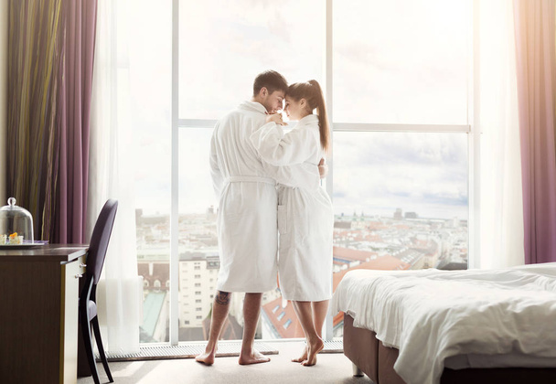 Pareja joven enamorada en habitación de hotel por la mañana
 - Foto, Imagen