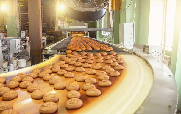 Kuchen auf automatischem Band oder Band, Prozess des Backens in Süßwarenfabriken oder Fabriken. Nahrungsmittelindustrie, Kekse und andere süße Brotwaren - Foto, Bild