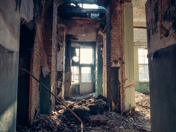 Corredor en ruinas de edificio abandonado, basura y paredes rotas sin puertas. Interior después de la guerra u otro desastre
 - Foto, Imagen
