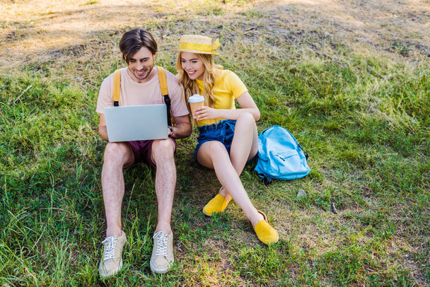 молодая пара с кофе идти с помощью ноутбука в парке
 - Фото, изображение