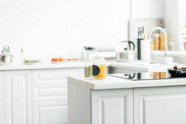 interno della moderna cucina bianca vuota con vasetti sul tavolo
 - Foto, immagini
