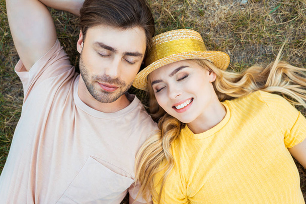 overhead view of couple in love resting on green grass in park - Photo, Image