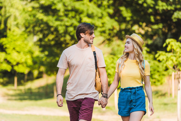portrait of happy couple in love walking in summer park together - Fotó, kép