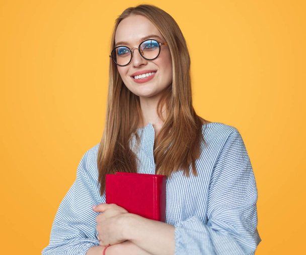 Pretty woman in glasses holding book - Foto, afbeelding