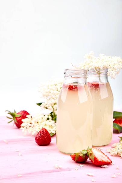 Kombucha tea with elderflower and strawberry on pink background. Homemade fermented infused drink. Summer Healthy natural probiotic flavored drink. Copy space - Photo, Image