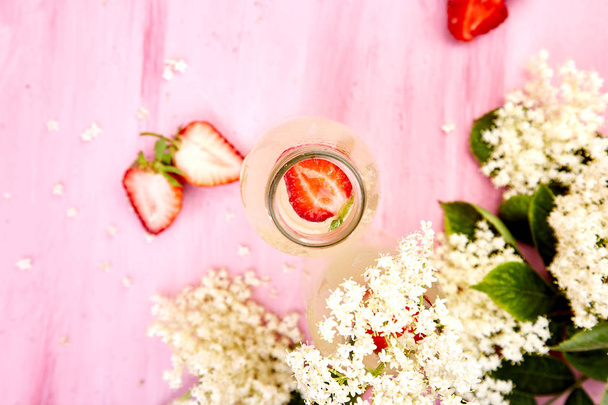 ニワトコの花とピンクの背景にイチゴのきのこ茶お茶。自家製発酵注入ドリンクです。夏の健康的な自然なプロバイオティクス風味ドリンクです。領域をコピーします。トップ ビュー. - 写真・画像