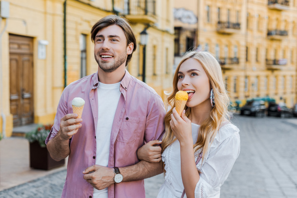 portrait of young couple with ice cream walking on street on summer day - Fotografie, Obrázek
