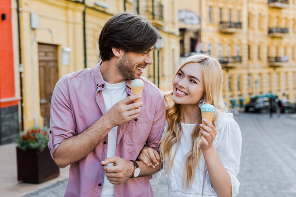 portrait of young couple with ice cream walking on street on summer day - Photo, image