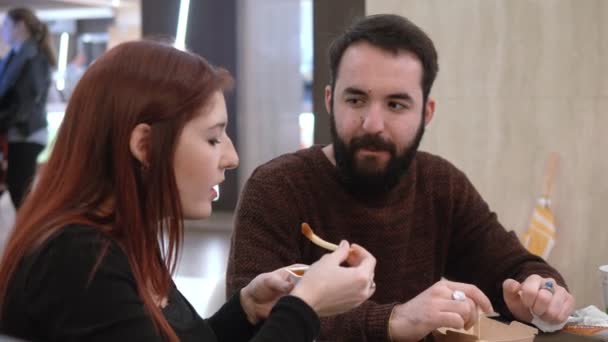 Portrait of young couple eating at fast food and chatting - Filmati, video