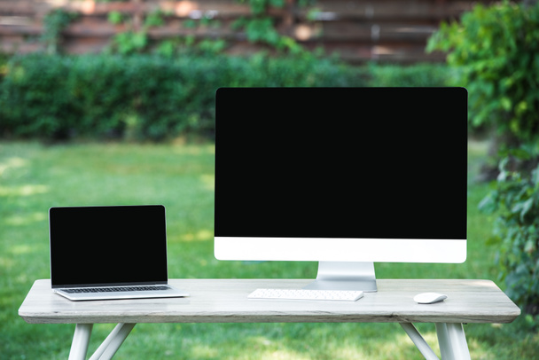 selective focus of laptop and computer with blank screens at table outdoors - Photo, Image
