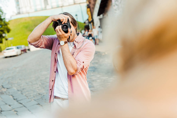 partial view of man taking picture of girlfriend on photo camera on street - Photo, image
