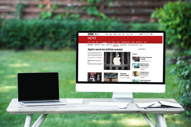 selective focus of laptop with blank screen computer with bbc news website at table outdoors - Fotografie, Obrázek