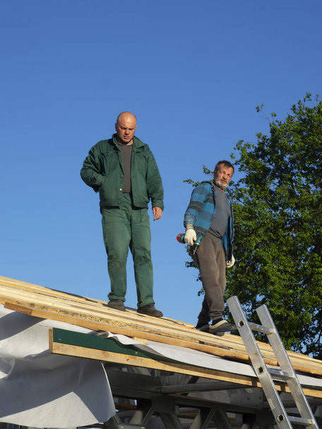 Caucasian men performs roofing work. Installation of wooden battens - Фото, зображення