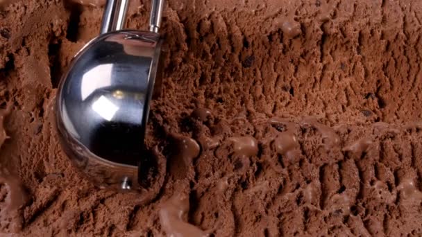 Chocolade-ijs schepte uit container met een lepel. Closeup 4k - Video