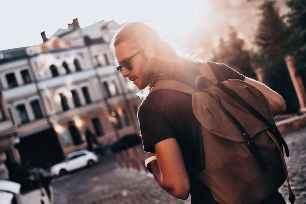 back view of handsome young man walking in city street  - Fotoğraf, Görsel
