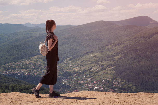 Mädchen mit Rucksack steht auf dem Hügel und bewundert die Aussicht. sonniger Tag - Foto, Bild