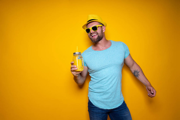 Man posing with bright orange drink - 写真・画像