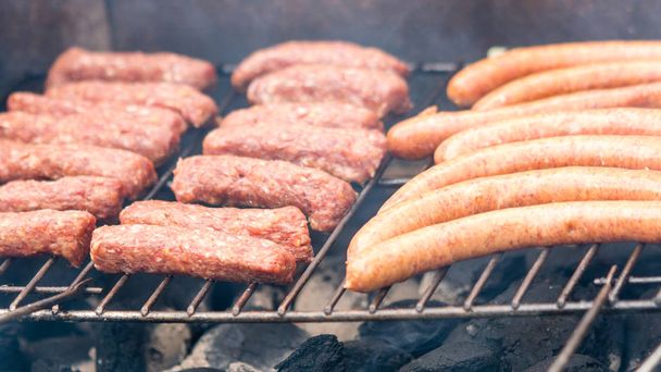 Grigliate di carne sui carboni ardenti su un barbecue con salsiccia, bistecca. Primo piano
. - Foto, immagini