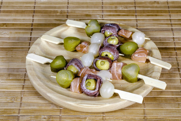 Delicioso prato de aperitivo com salmão, anchovas e azeitonas. Tortilla espanhola montada
 - Foto, Imagem