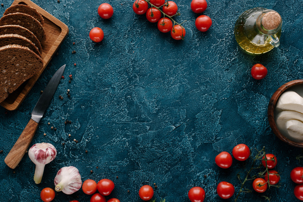 Стиглі червоні помідори з хлібом і спеціями на темно-синьому столі
 - Фото, зображення