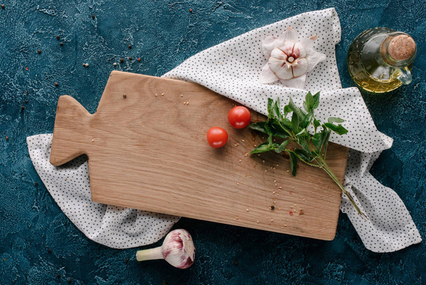 Cutting board with tomatoes and basil on dark blue table - Photo, Image