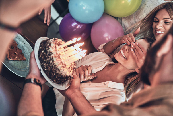 happy people celebrating birthday, smiling woman with covered eyes waiting for cake  - Фото, изображение