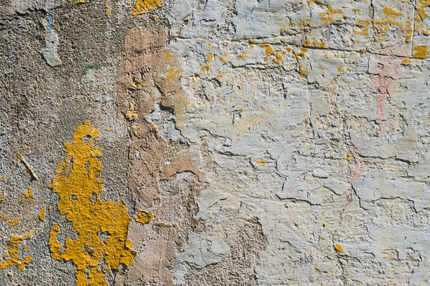 Textured grunge background. Volumetric plastered wall with a multilayer cracked coating. Orange chips on the whitewashed wall. Grunge texture with a deep pattern - Foto, afbeelding