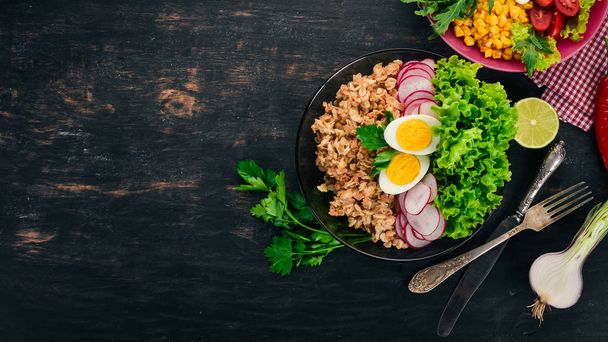 Healthy food. Oatmeal, lettuce, radish, egg. On a wooden background. Top view. Free copy space. - Фото, зображення