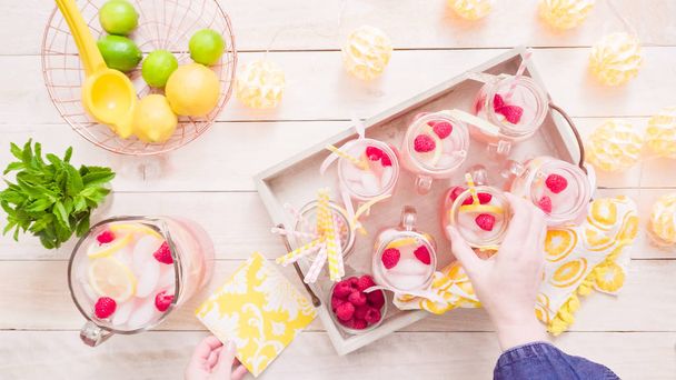 Stap voor stap. Voorbereiding raspberry limonade met verse citroenen en frambozen in drinken mason jars. - Foto, afbeelding