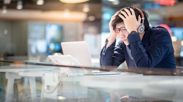 Jovem homem de negócios asiático sentindo-se estressado e frustrado enquanto trabalhava com computador portátil. Empreendedor do sexo masculino a meter-se em sarilhos com o trabalho. estilo de vida freelance no espaço de trabalho urbano
. - Foto, Imagem