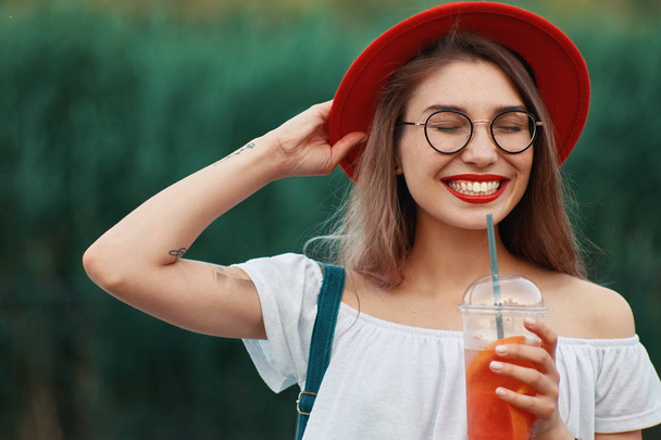 Młoda kobieta stylowe mając przy drinku podczas chodzenia - Zdjęcie, obraz