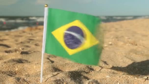 Σημαία της Βραζιλίας σε μια αμμώδη παραλία. - Πλάνα, βίντεο