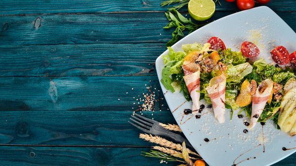 Fresh salad with bacon, avocado and tomatoes. On a wooden background. Top view. Copy space. - Foto, Bild