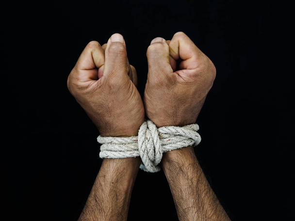 Le mani dell'uomo erano legate con una corda. Concetto di Giornata dei Diritti Umani, Violenza, Terrorizzato
. - Foto, immagini