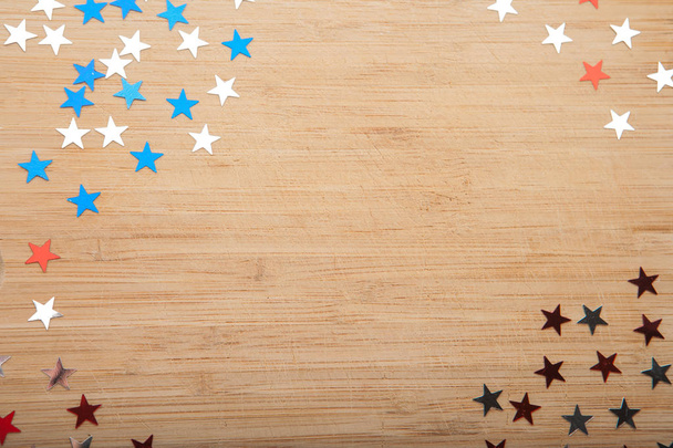 Konfeti yıldız ahşap arka plan üzerinde. Temmuz 4, bağımsızlık günü, kart, ABD bayrağı renklerde davet. Üstten görüntülemek, alan boş. - Fotoğraf, Görsel